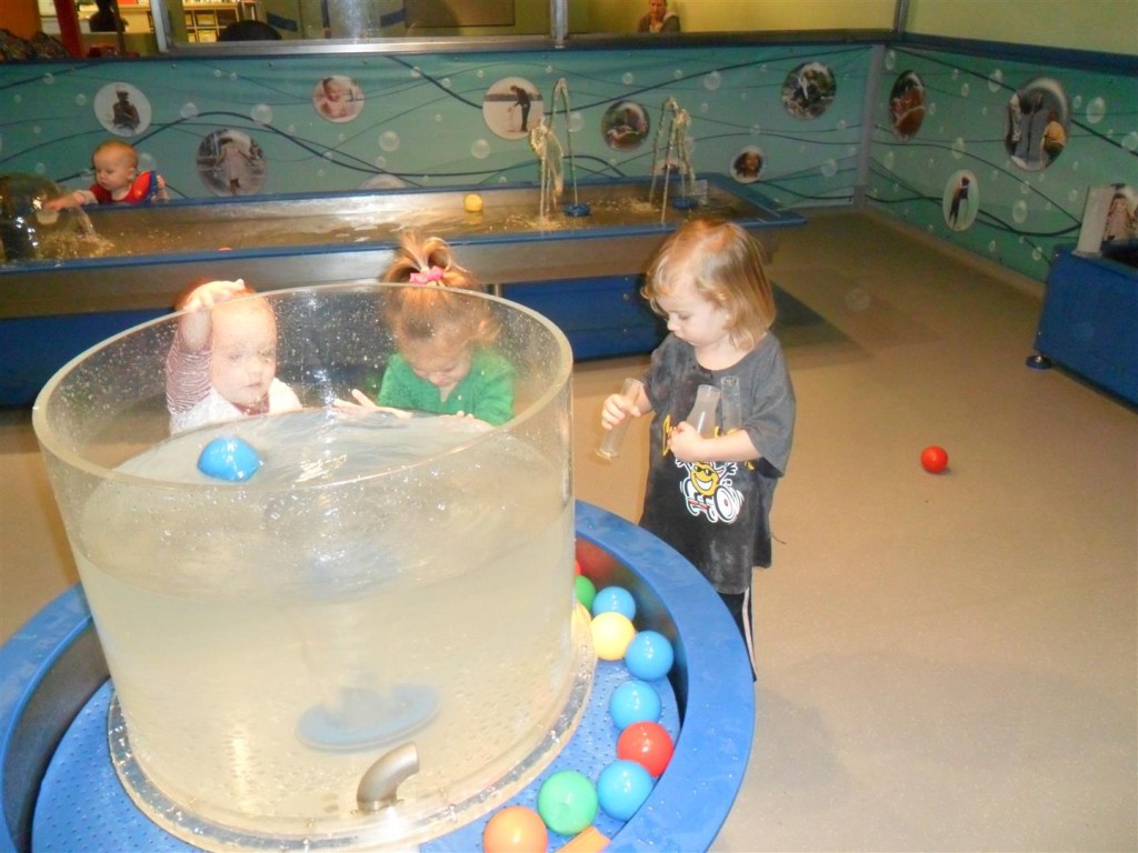 We played at two different water stations!  Maggie is carefully carrying three beakers full of water to pour into the water here.