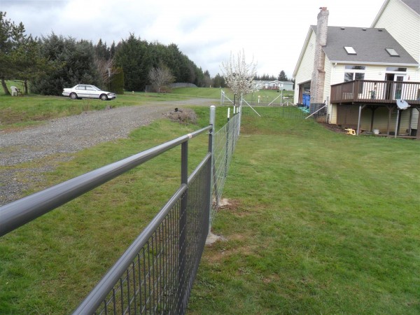 We decided to line up the fence with the corner of the shop.  And we decided to not close in the driveway with the fence at the top.  Maybe a mistake, since now there is grass between the fence and the driveway that I don't know what to do with.