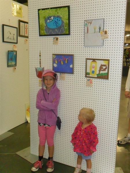 Here is Anna under two of her pieces of artwork at the county fair!  The blue one with butterflies and the one of the pool above that.  So proud of her!  She's proud of her too!