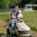Papa using the riding lawn mower to tow a big pile of blackberry vines. Maggie got to have a ride! 